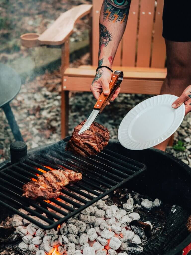 Firepit grill with steak cooking at Adohi Cabin, a romantic boho-modern getaway in North Georgia